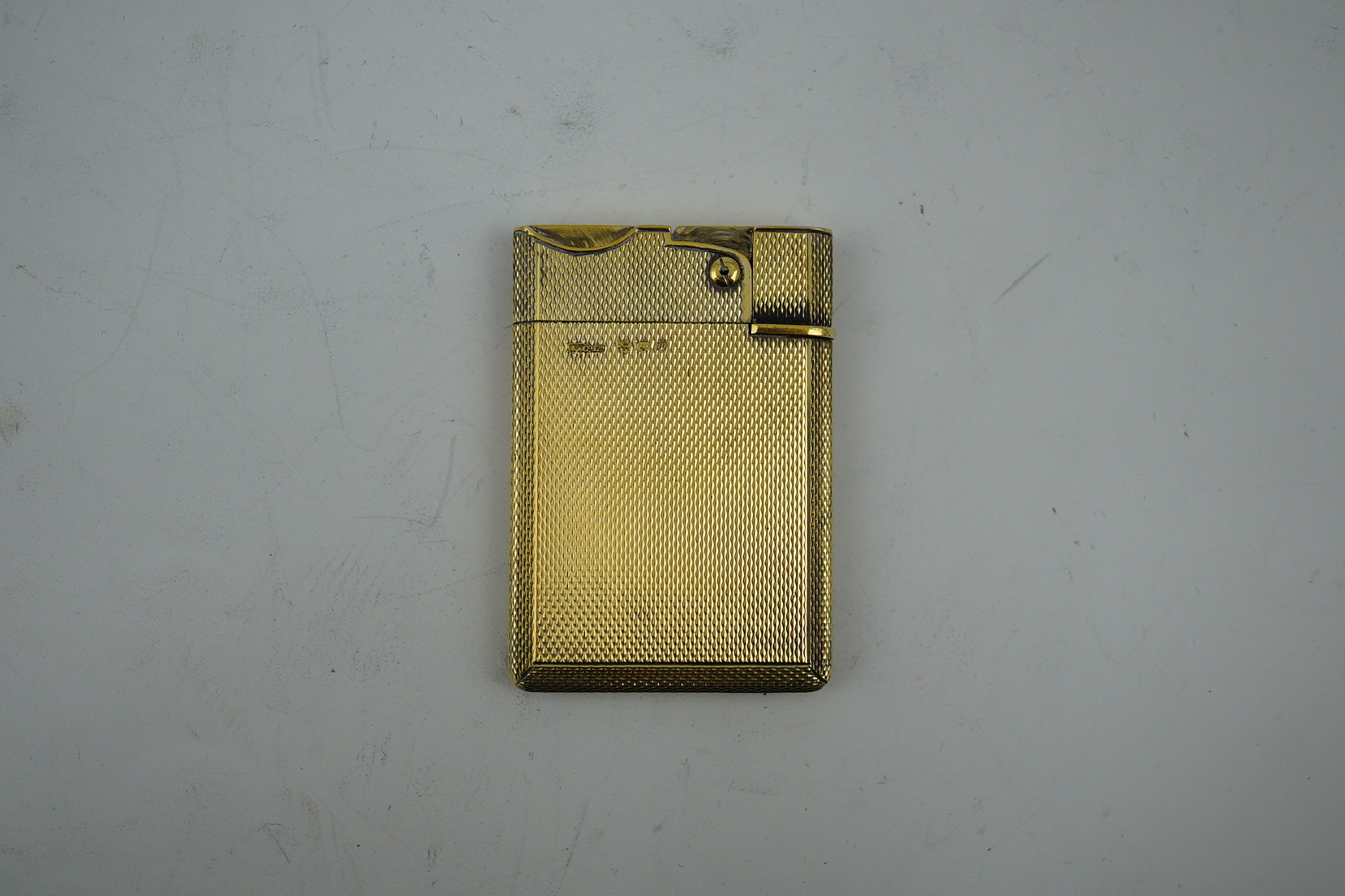 An Elizabeth II Asprey & Co engine turned silver gilt 'wafer' lighter